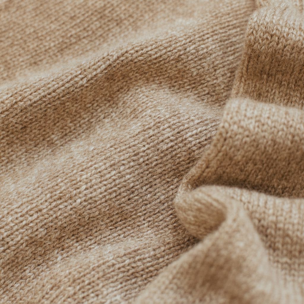 dili fabric detail — cashmere and wool knit texture in warm camel tones